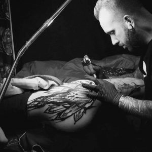 le tatoueur Lahhel entrain de tatouer sur une cuisse
